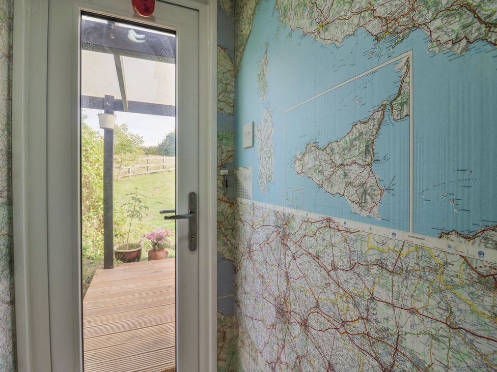 A door with map wallpaper in a hallway at Orchard Lodge in Dover