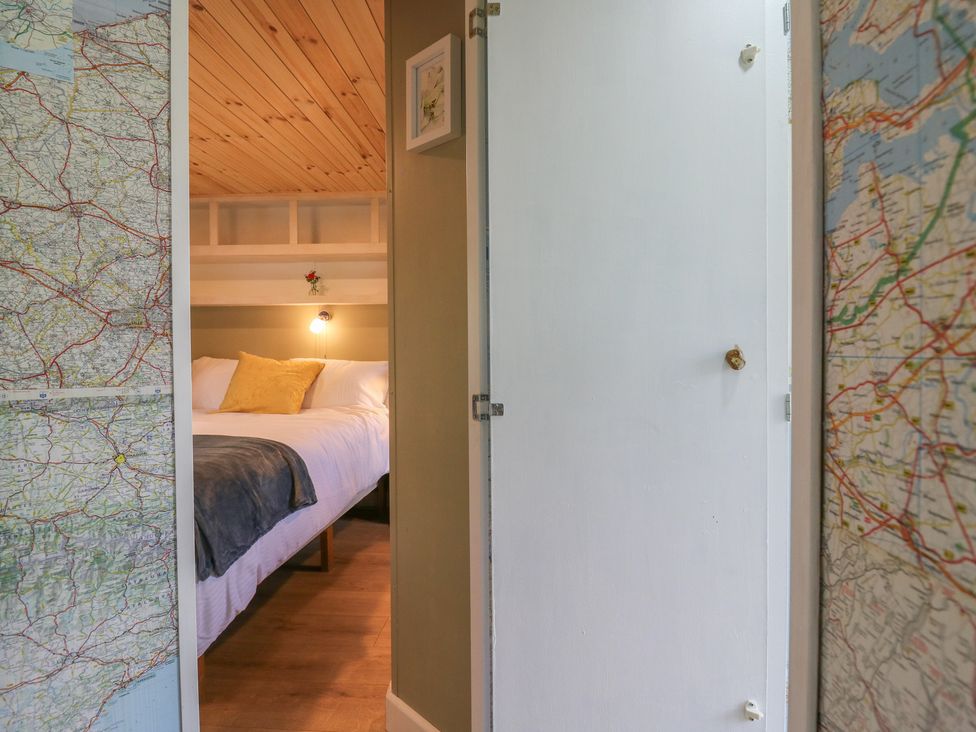 A bedroom with a bed visible through a door at Orchard Lodge in Dover