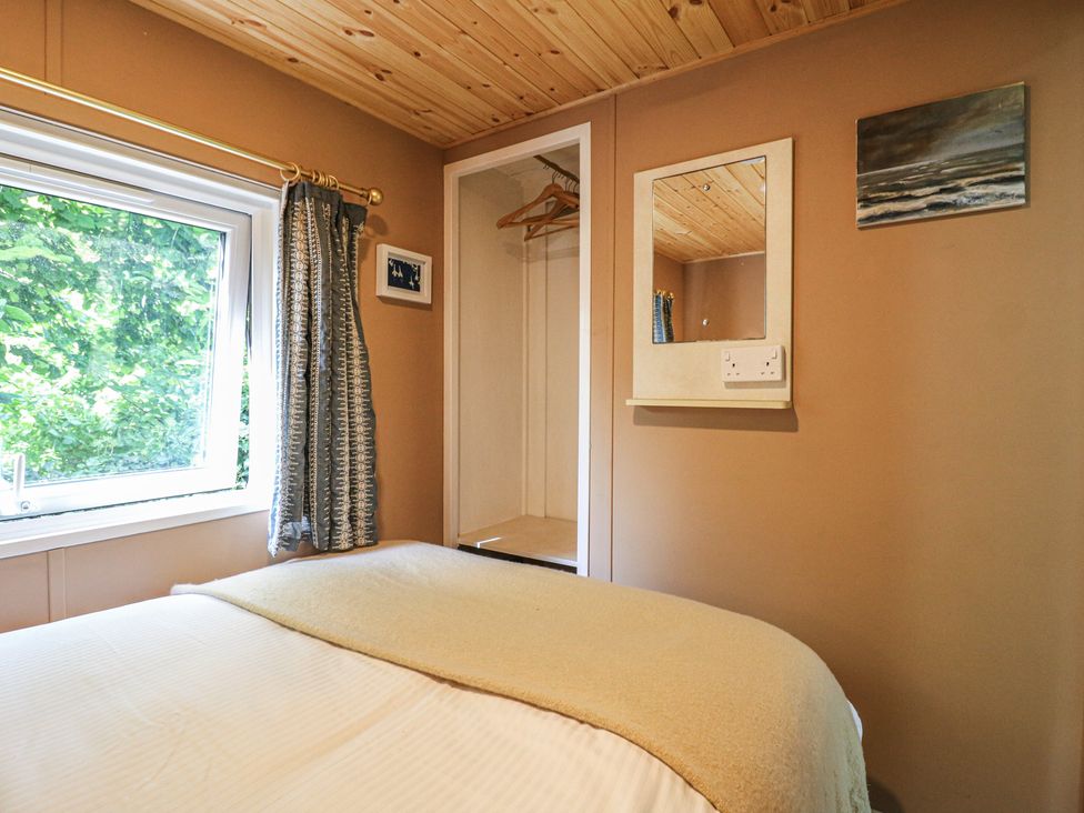 A bedroom with a bed and wardrobe at Orchard Lodge in Dover