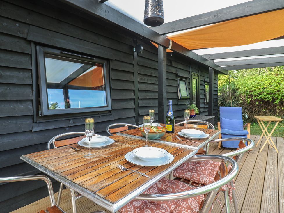 A deck with a table and chairs at Orchard Lodge in Dover