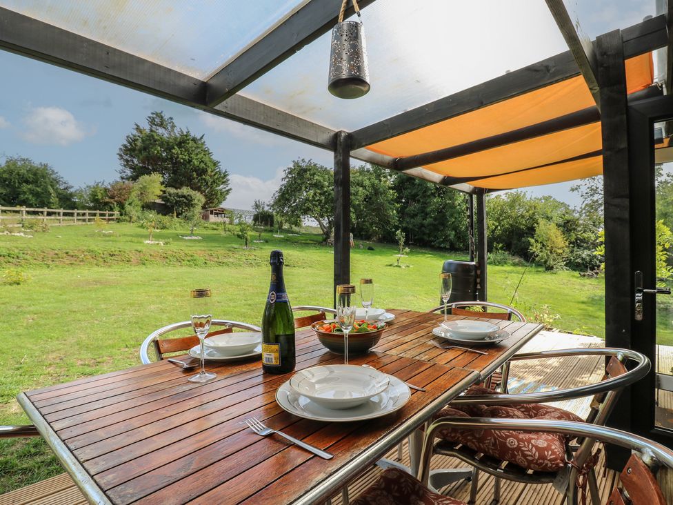 An outdoor dining area with a table set for a meal at Orchard Lodge in Dover