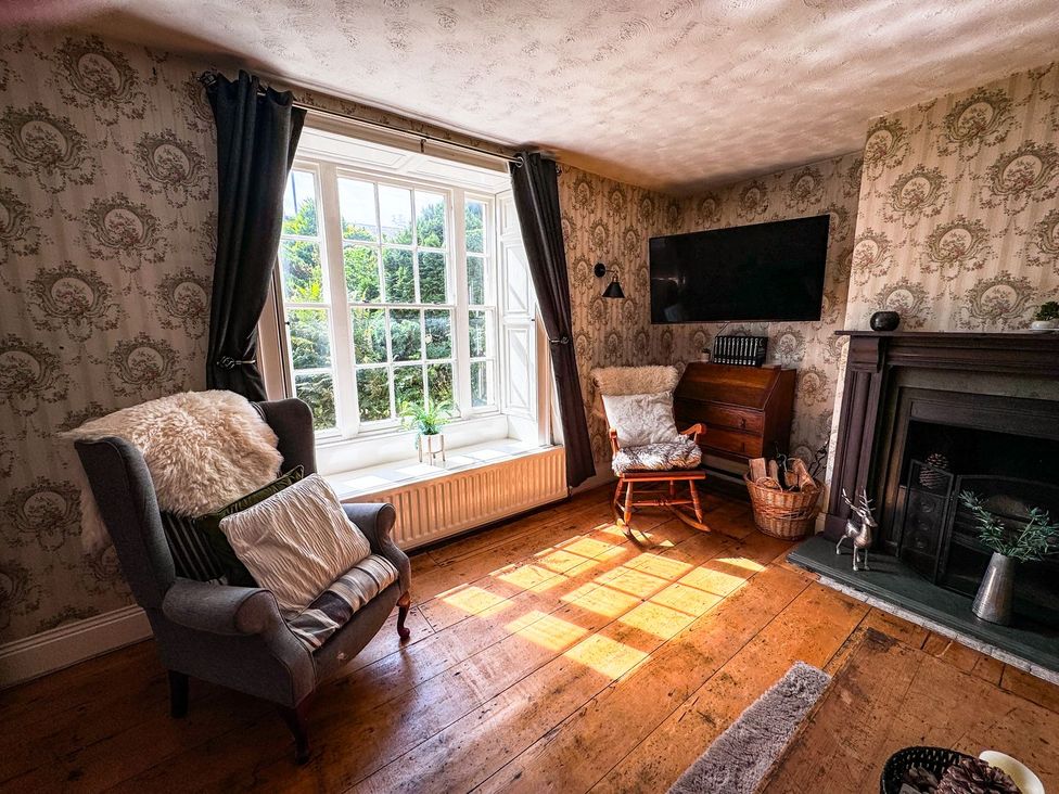 A living room with an armchair and television at Prudhoe Cottage in Prudhoe