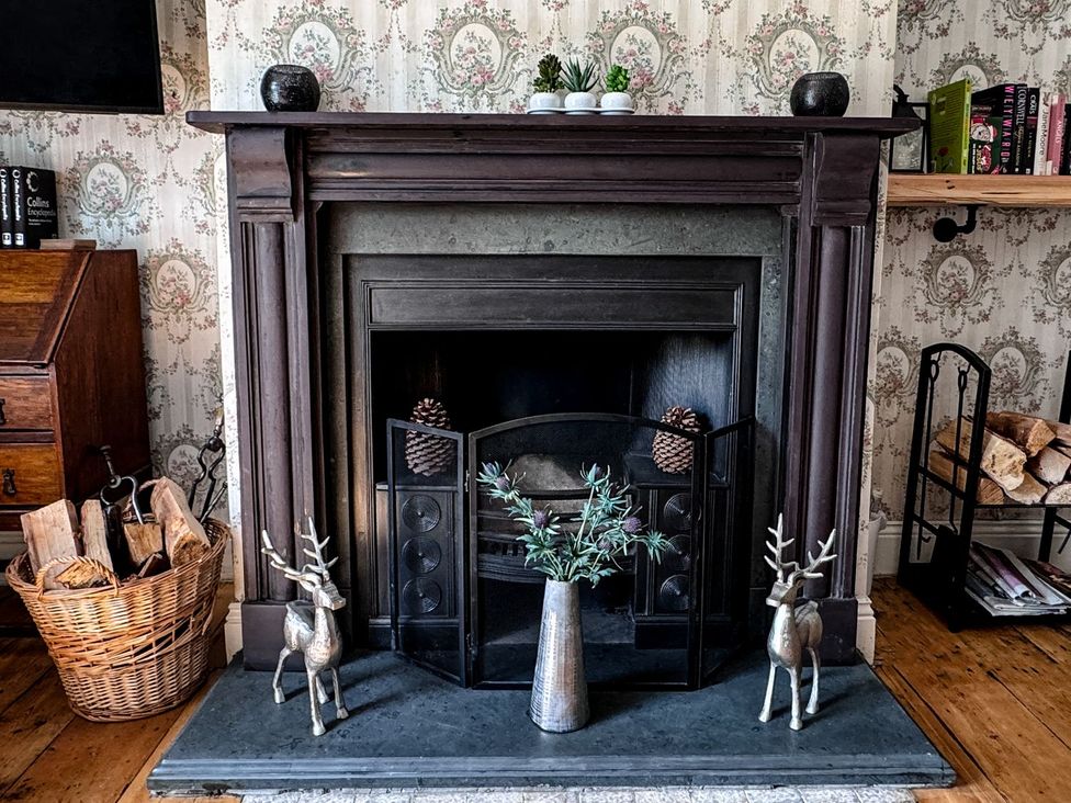 A fireplace with decorative items at Prudhoe Cottage in Prudhoe