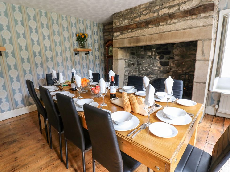 A dining room with a wooden table set for a meal at Prudhoe Cottage in Prudhoe