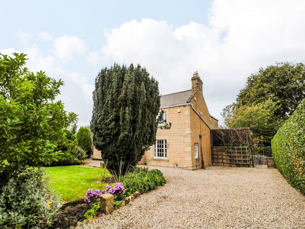 A house with trees and a garden at Prudhoe Cottage in Prudhoe