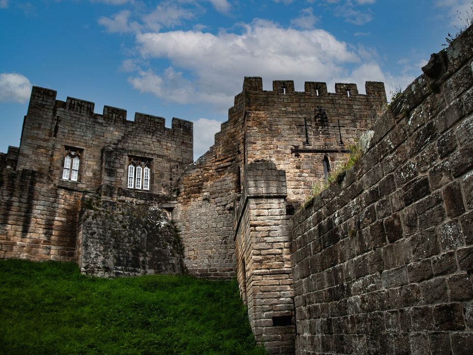 A stone castle structure with grass in front at Prudhoe Cottage in Prudhoe