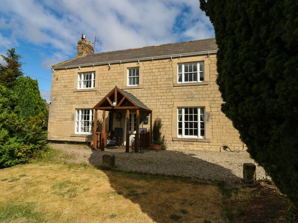 A house with a front porch and garden at Prudhoe Cottage in Prudhoe