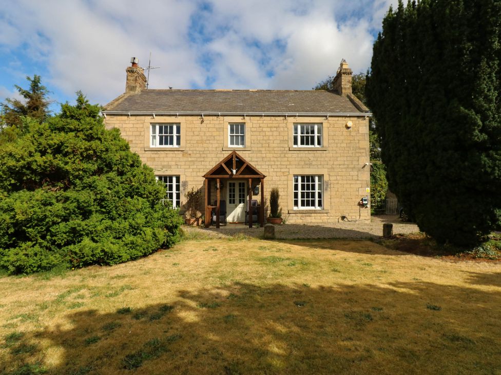 A house with a front porch and garden at Prudhoe Cottage in Prudhoe