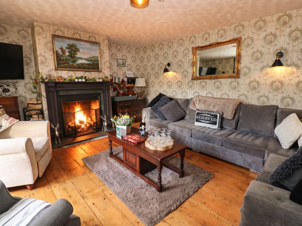A living room with a fireplace and sofa at Prudhoe Cottage in Prudhoe