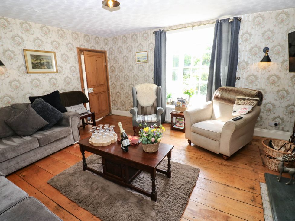 A living room with a sofa and armchair at Prudhoe Cottage in Prudhoe