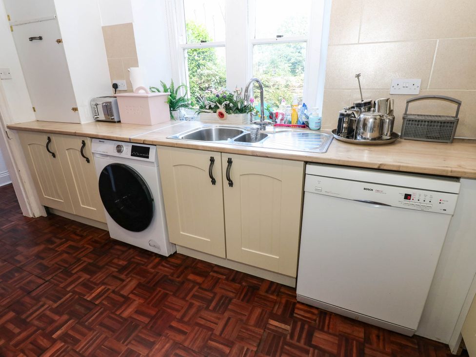 A kitchen with a sink, washing machine, and dishwasher at Prudhoe Cottage in Prudhoe