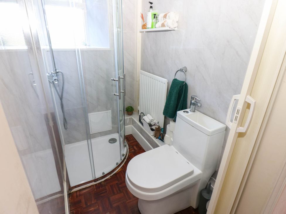 A bathroom with a shower, toilet, and radiator at Prudhoe Cottage in Prudhoe