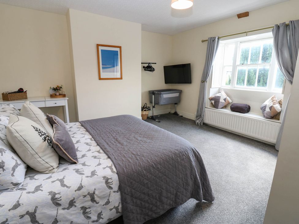 A bedroom with a bed and window seat at Prudhoe Cottage in Prudhoe