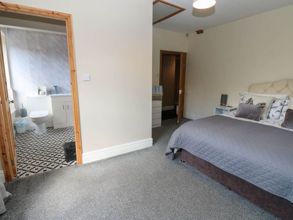 A bedroom with a view into the bathroom at Prudhoe Cottage in Prudhoe