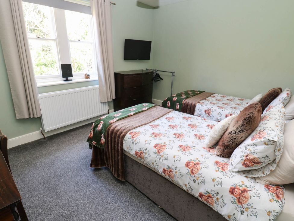 A bedroom with two beds and a television at Prudhoe Cottage in Prudhoe