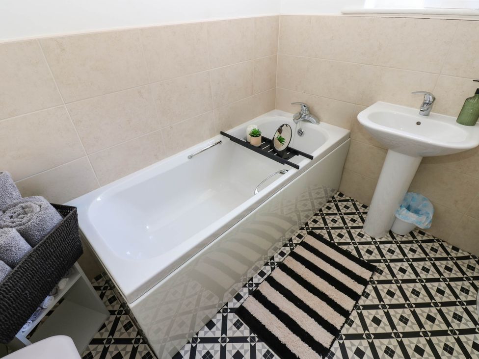 A bathroom with a bathtub and sink at Prudhoe Cottage in Prudhoe