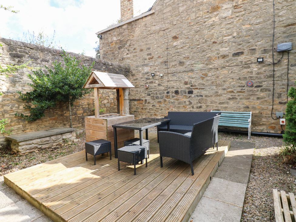 A garden with seating area and wooden decking at Prudhoe Cottage in Prudhoe