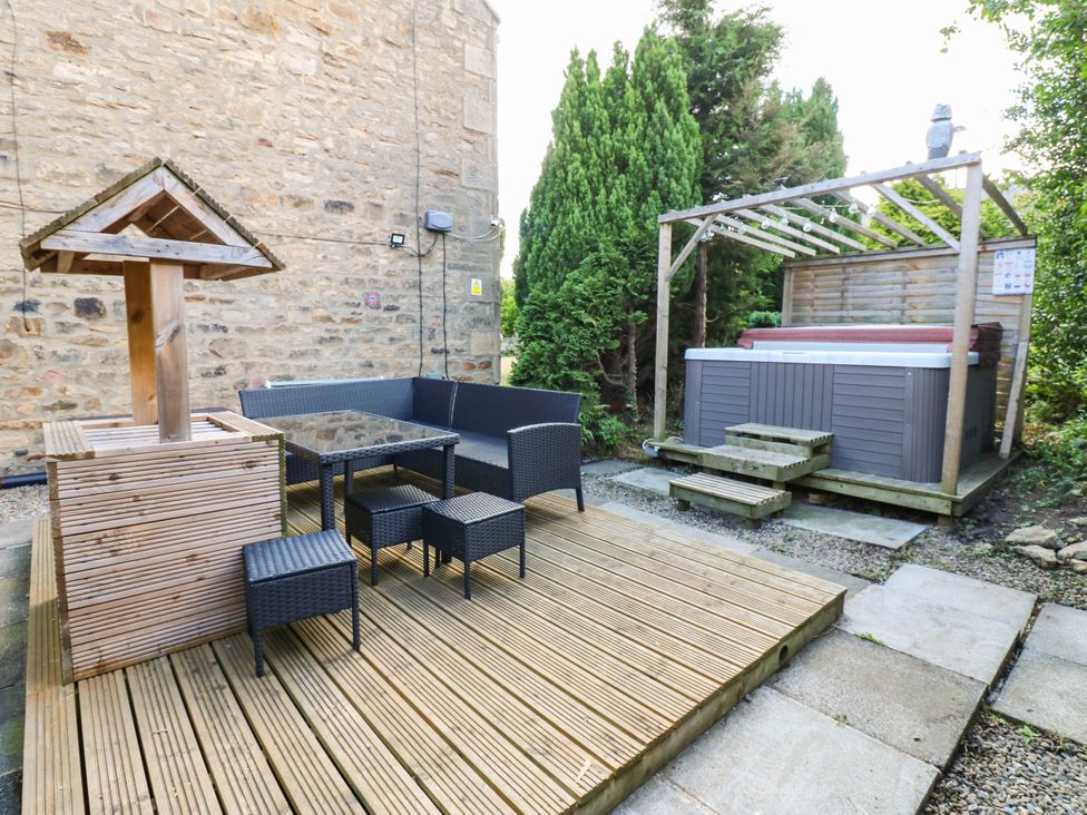 A garden with a hot tub and seating area at Prudhoe Cottage in Prudhoe