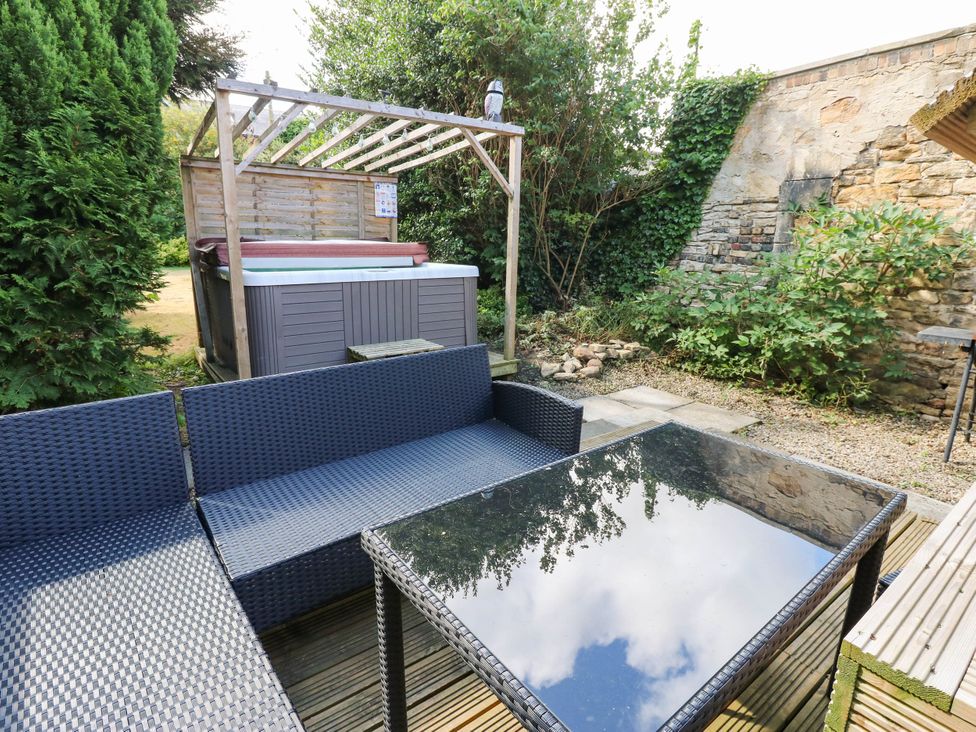 A garden with a hot tub and seating area at Prudhoe Cottage in Prudhoe