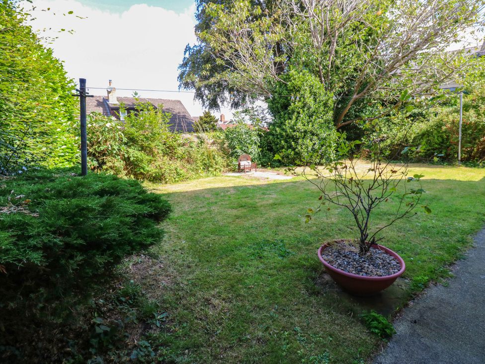 A garden area with grass, trees, and a plant pot at Prudhoe Cottage in Prudhoe
