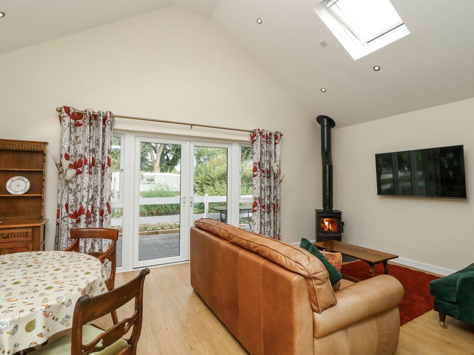 A living room with a sofa and wood stove at Jasper Lodge in Lincoln