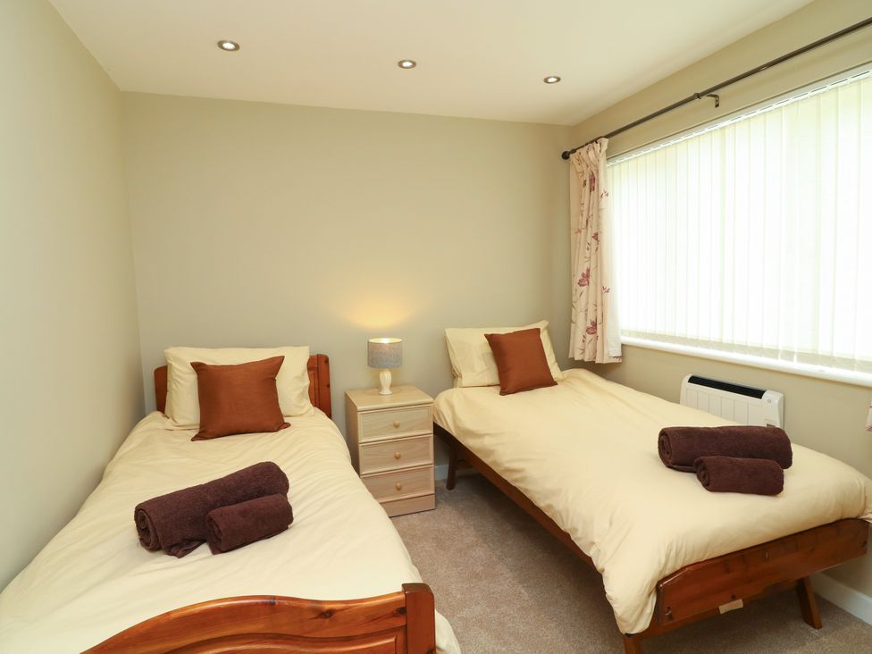 A bedroom with two single beds and a nightstand at Jasper Lodge in Lincoln