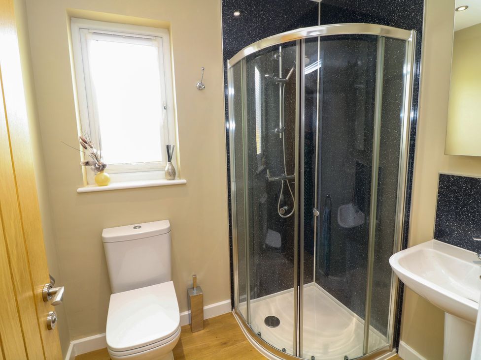 A bathroom with a shower, toilet, and sink at Jasper Lodge in Lincoln