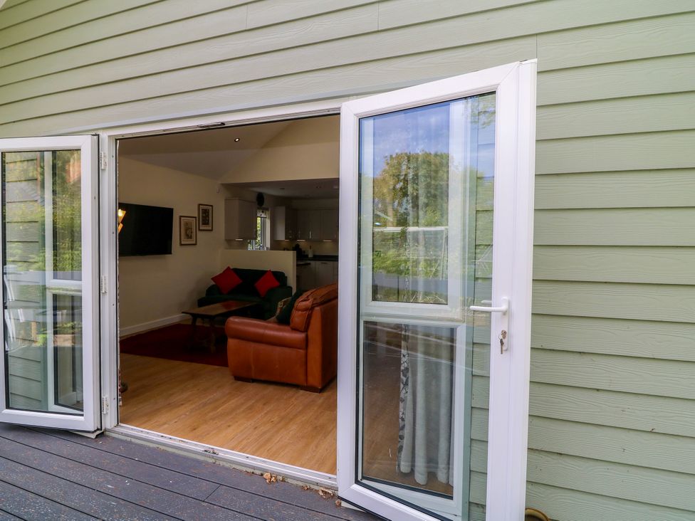 A living room view from outside with seating and a television at Jasper Lodge in Lincoln