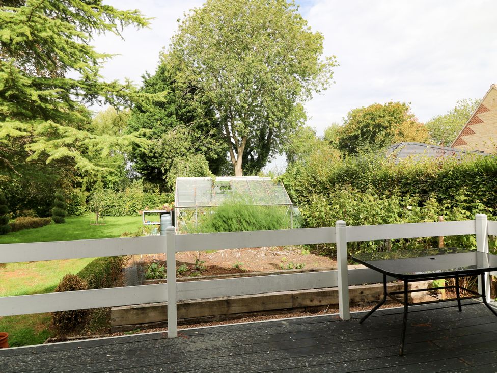A garden with a greenhouse and a table at Jasper Lodge in Lincoln