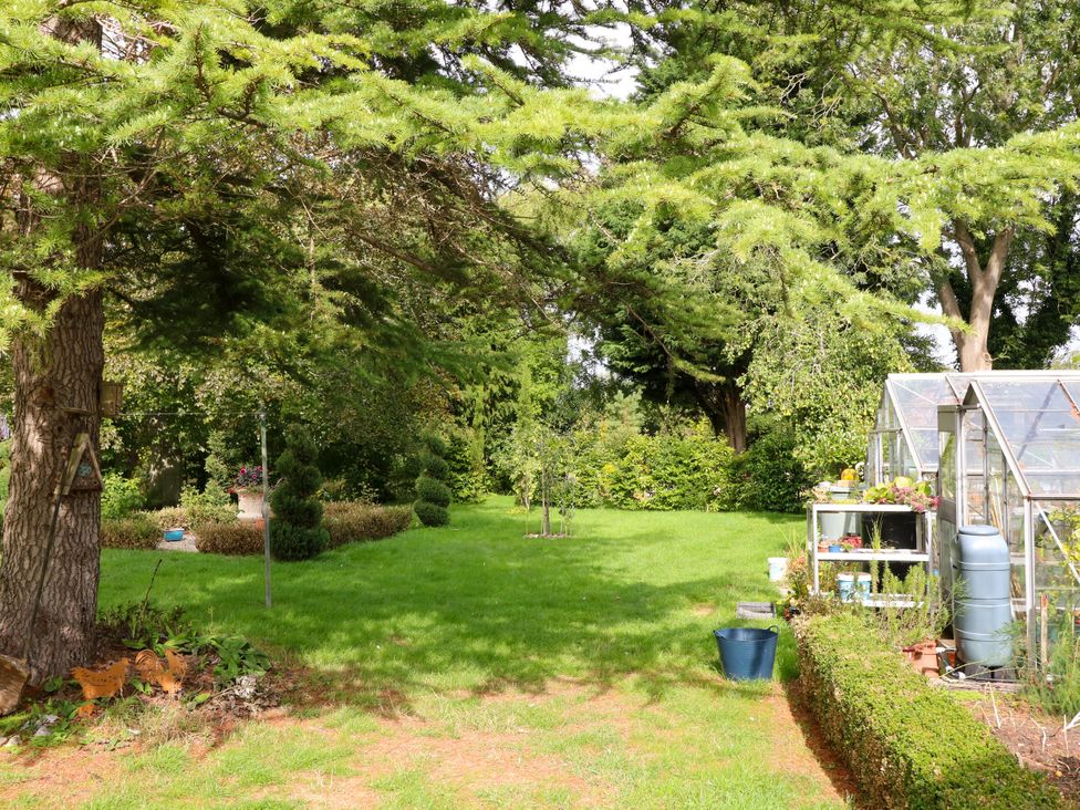 A garden with a greenhouse and greenery at Jasper Lodge in Lincoln