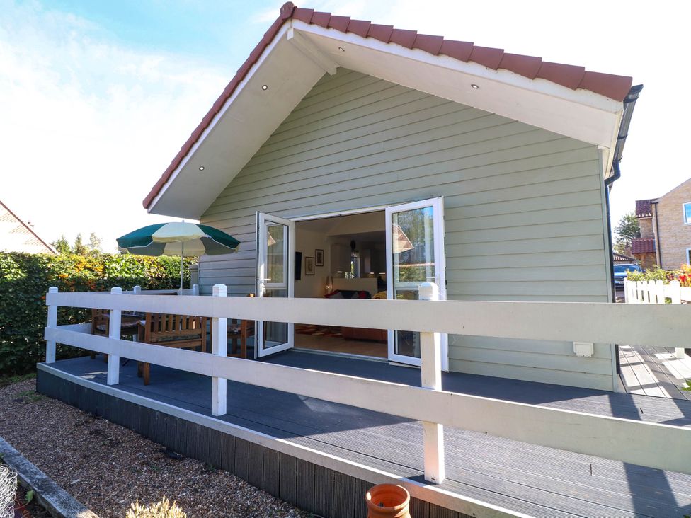 A house with a deck and umbrella at Jasper Lodge in Welton