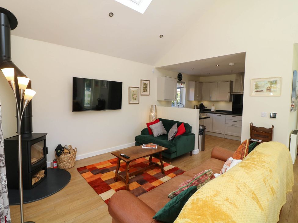 A living room with a sofa, coffee table, and television at Jasper Lodge in Welton