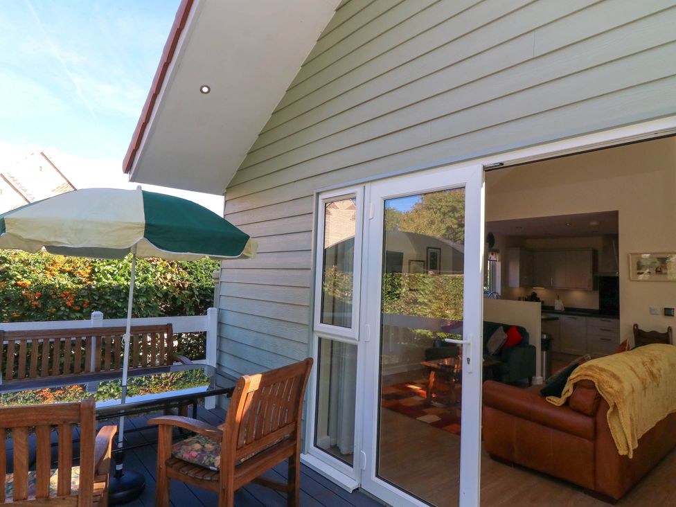 A patio with furniture and an umbrella at Jasper Lodge Welton