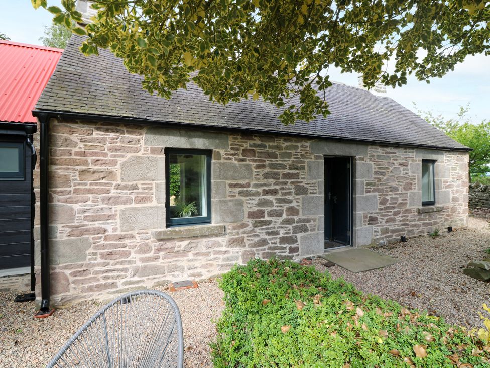 A stone cottage with a front door and window at Doocot Wood Cottage Forfar