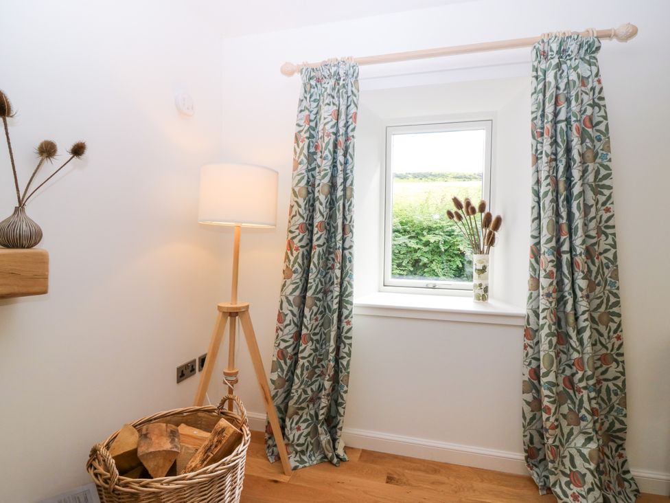 A cozy space with a window and a lamp at Doocot Wood Cottage in Forfar