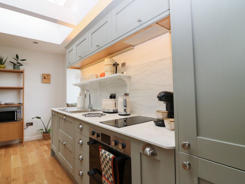 A kitchen with a sink and stove at Doocot Wood Cottage in Forfar