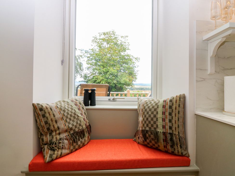 A nook with cushions and binoculars at Doocot Wood Cottage in Forfar