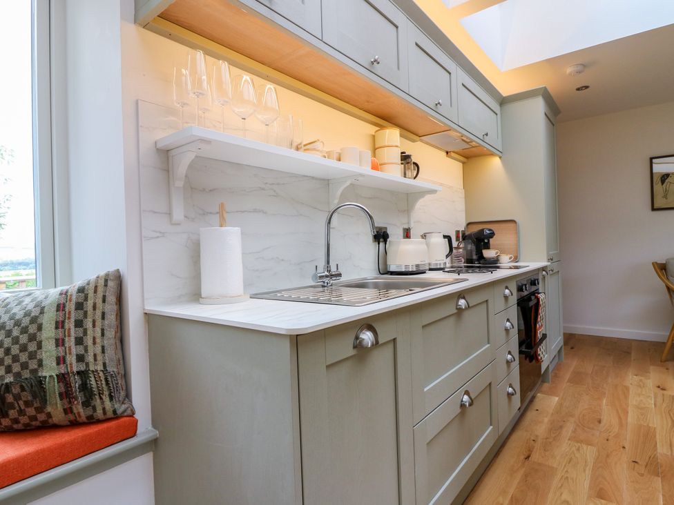 A kitchen with a sink and cabinets at Doo'cot Wood Cottage in Forfar