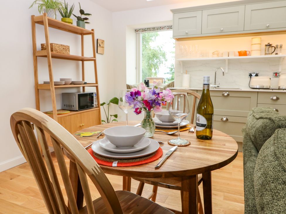 A dining room with a table set for two at Doocot Wood Cottage in Forfar