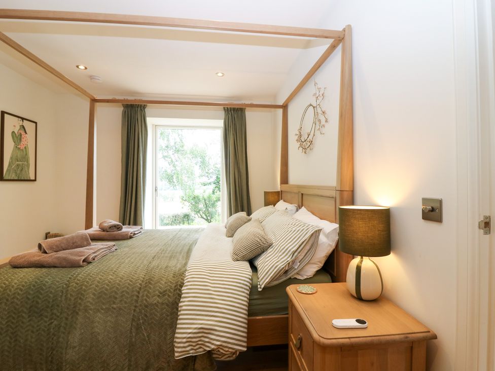A bedroom with a bed and bedside table at Doocot Wood Cottage, Forfar