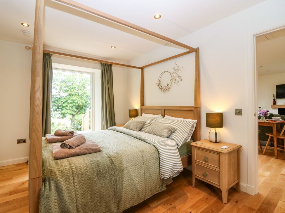 A bedroom with a bed and a window at Doo'cot Wood Cottage Forfar