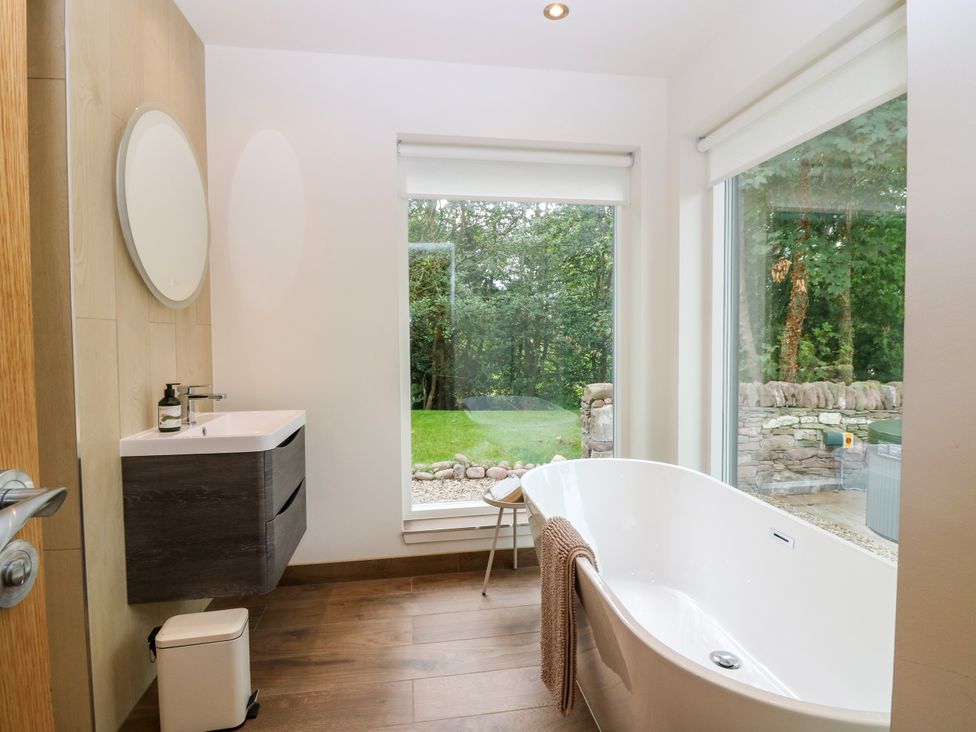 A bathroom with a bathtub and sink at Doo'cot Wood Cottage in Forfar