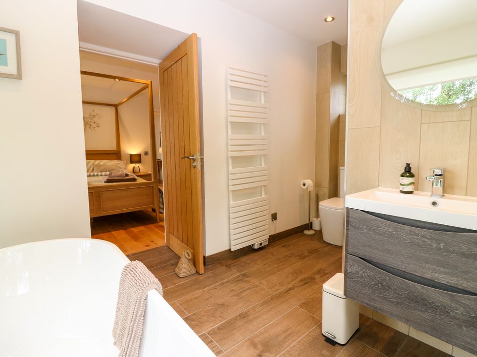 A bathroom with a bathtub, toilet and sink at Doocot Wood Cottage in Forfar