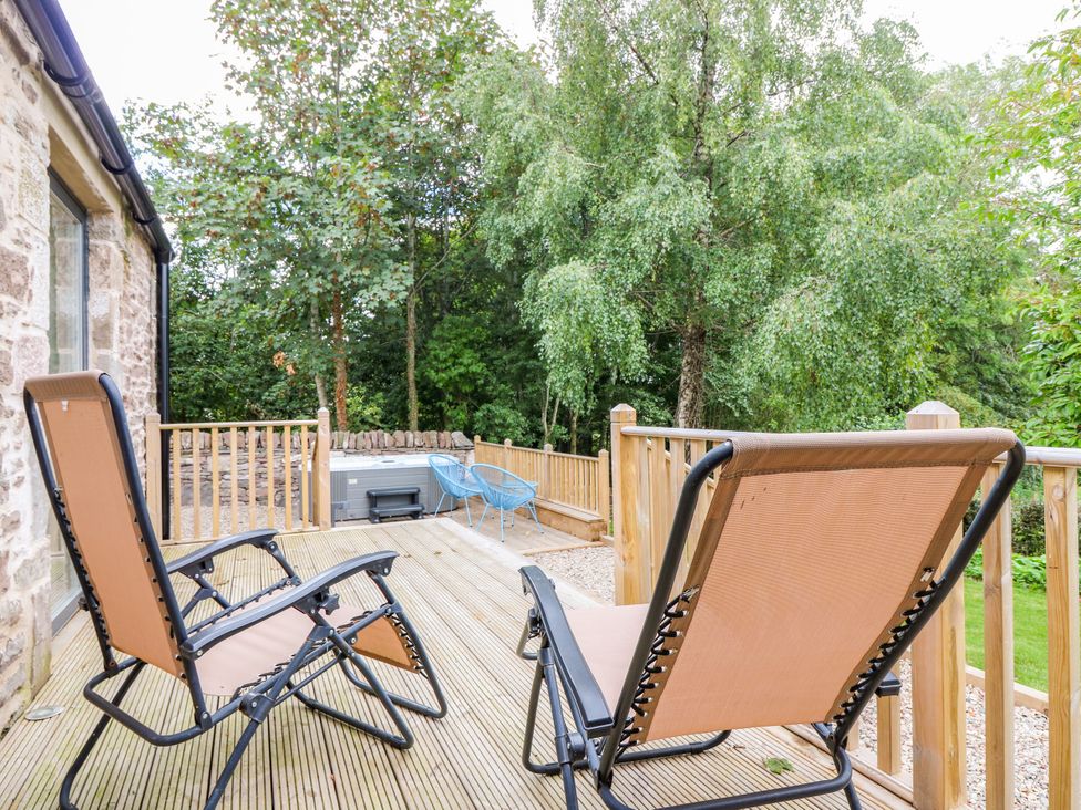 A deck with two chairs and a hot tub at Doocot Wood Cottage in Forfar