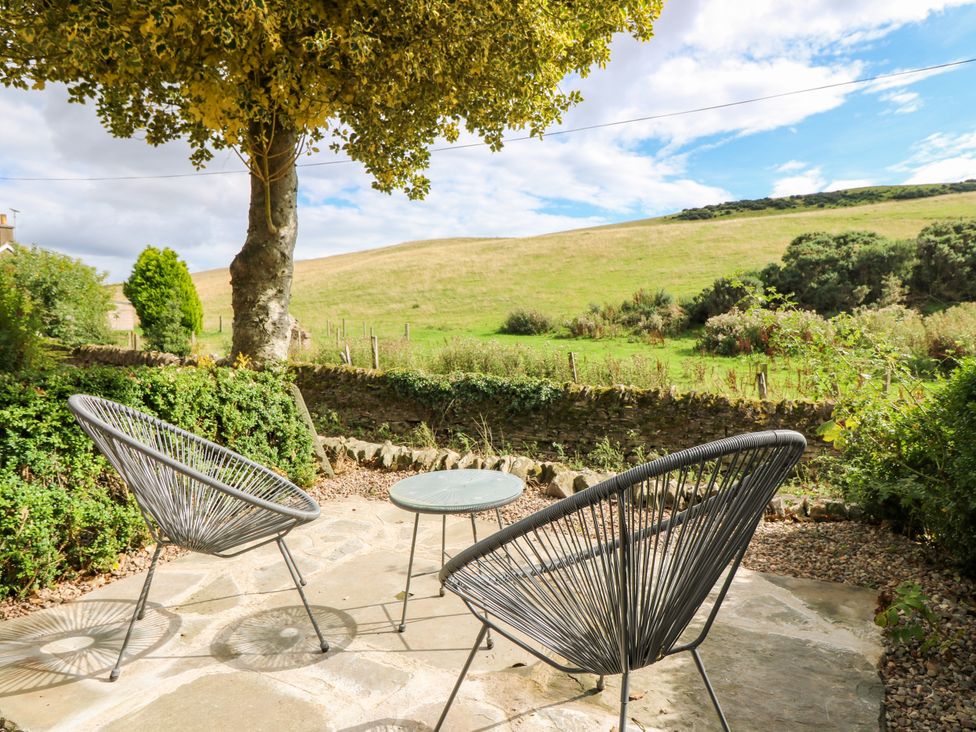 Outdoor patio with seating and table at Doo'cot Wood Cottage Forfar
