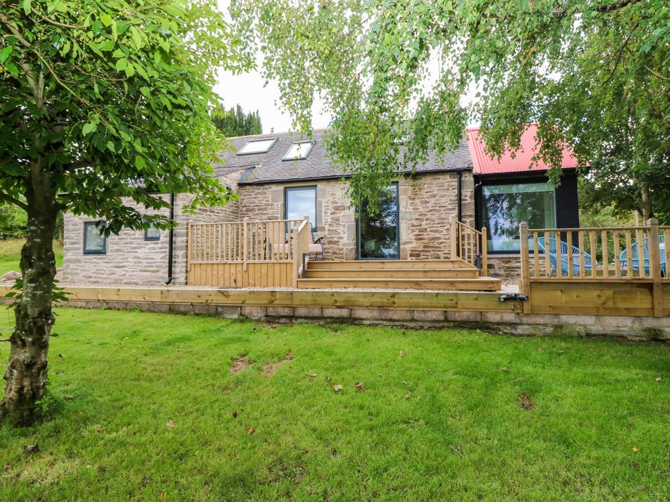 A house with a wooden deck and steps at Doocot Wood Cottage Forfar