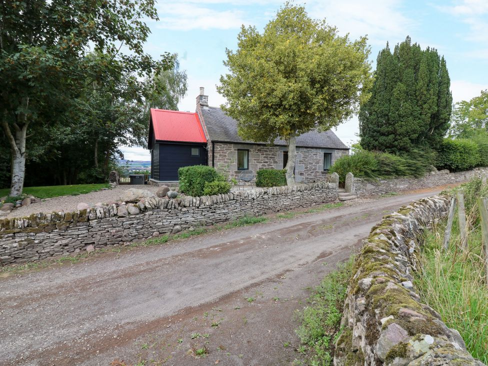 A cottage with stone walls and a red roof at Doo'cot Wood Cottage Forfar