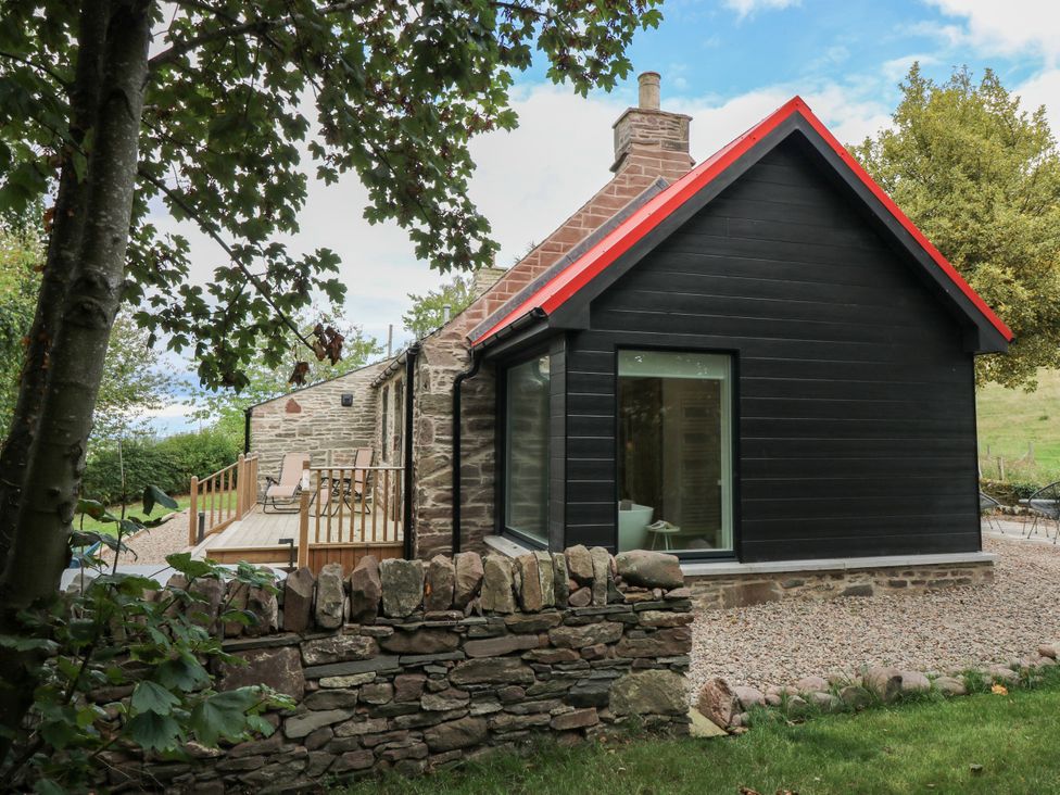 A house with a deck and garden at Doocot Wood Cottage in Forfar