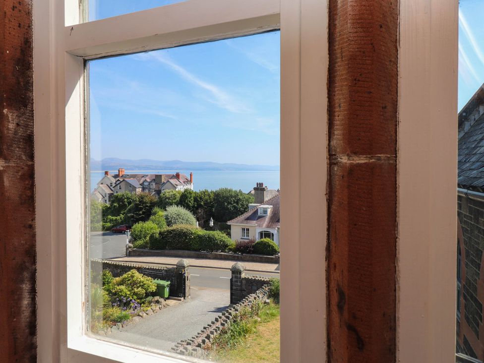 A view from a window showing houses and the ocean at Flat 16 Criccieth