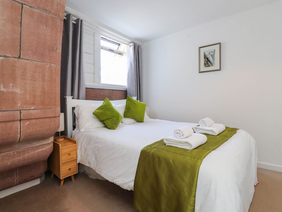 A bedroom with a bed and bedside table at Flat 16 in Criccieth